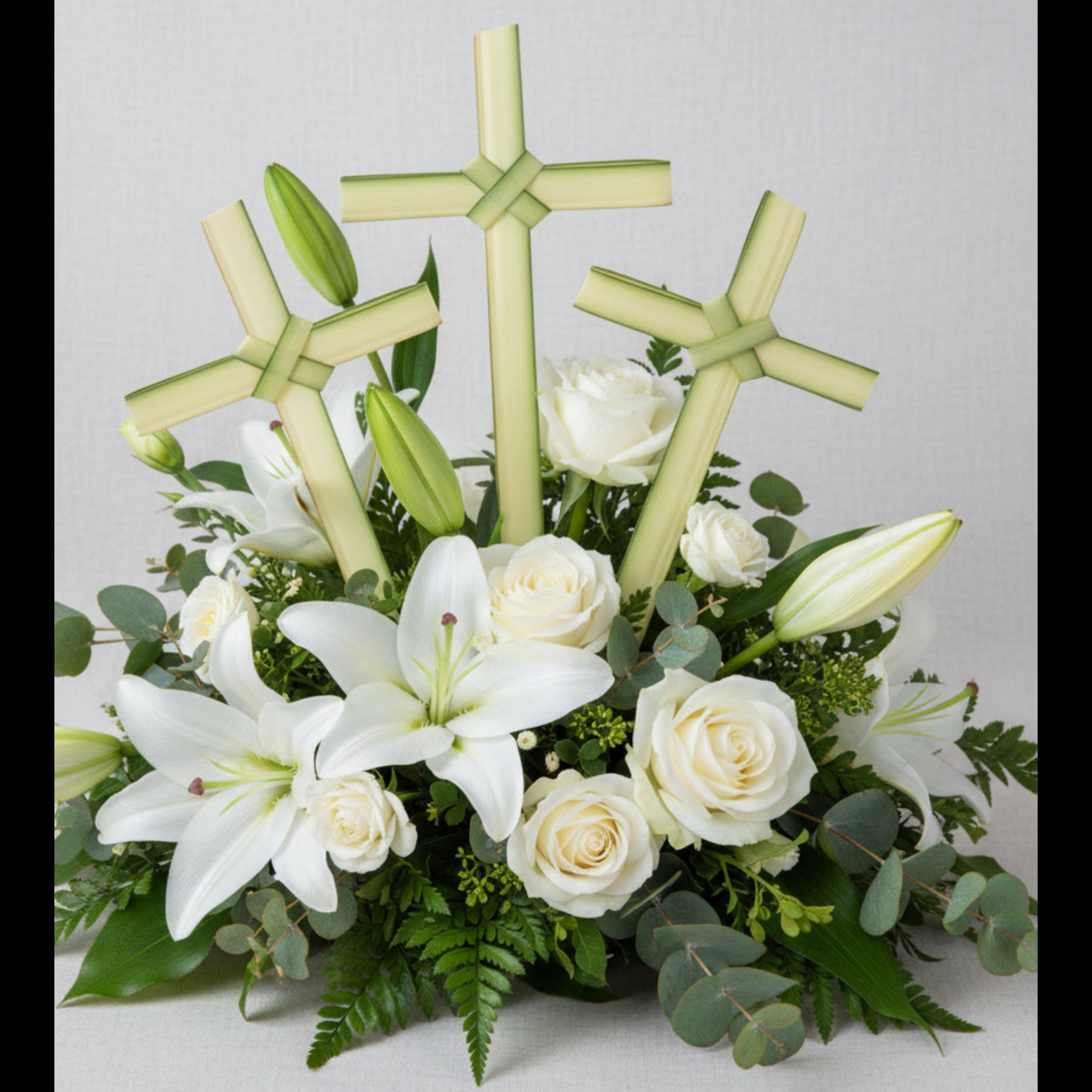 Cross-shaped green palm leaves on a floral arrangement