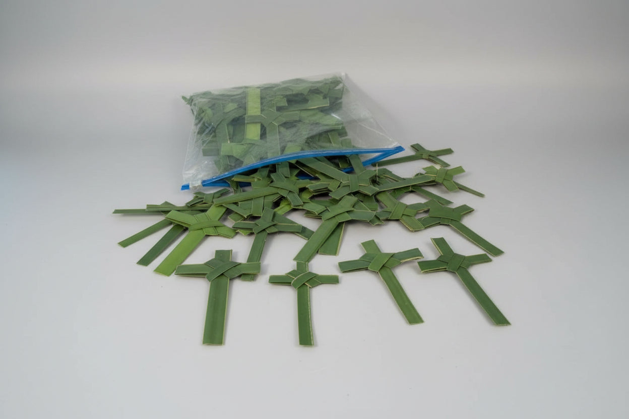 Green paper crosses on a wooden surface with a bag of additional crosses in the background.