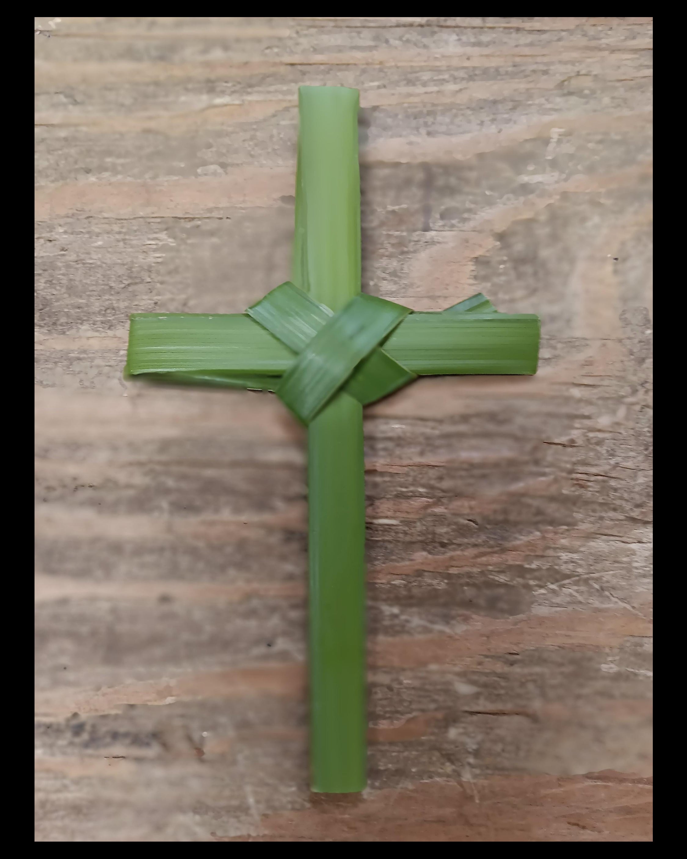 Green hand folded Cross on a wooden surface
